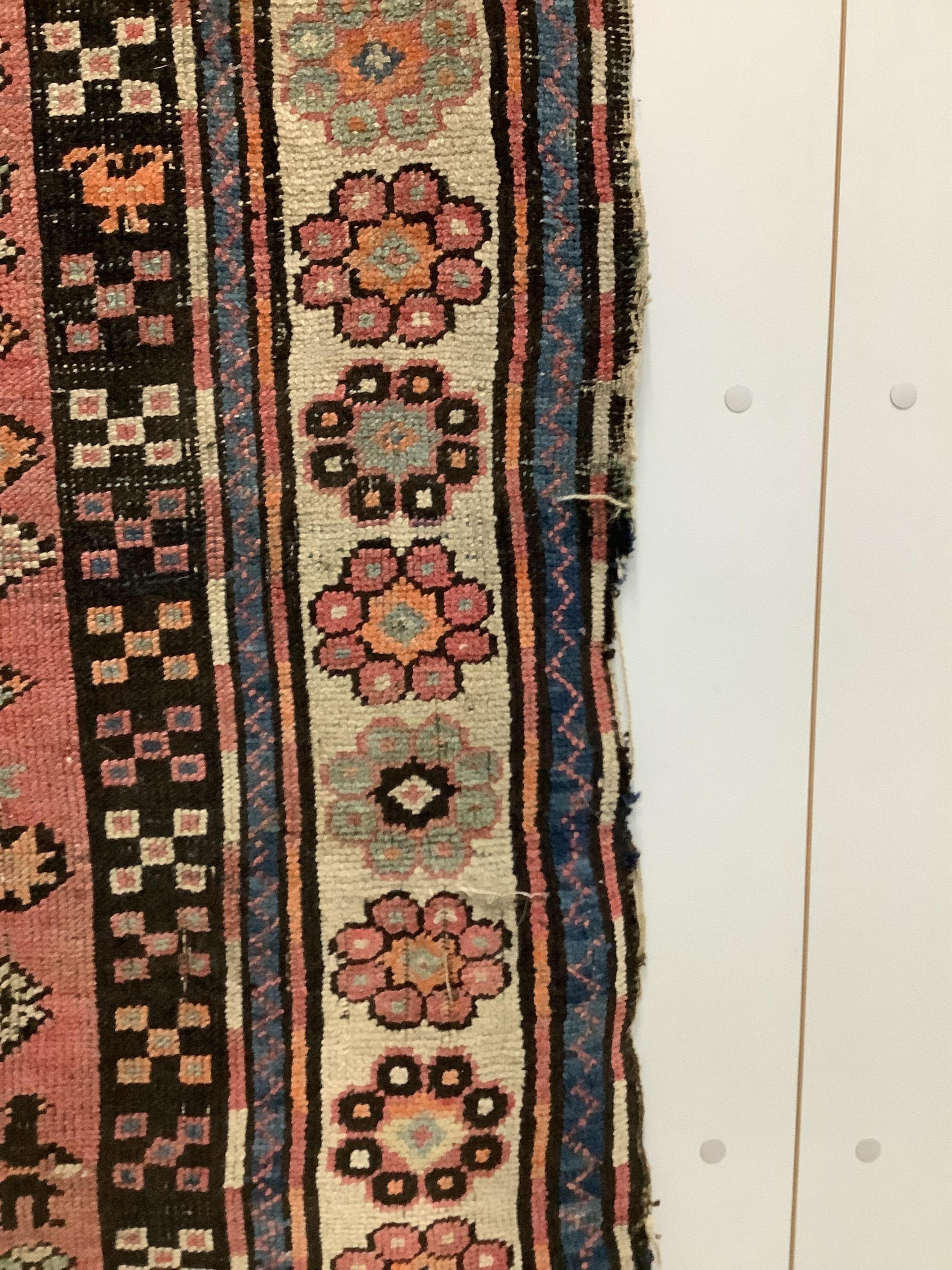 A Caucasian red ground rug, 265 x 130cm. Condition - faded with some wear at the margins